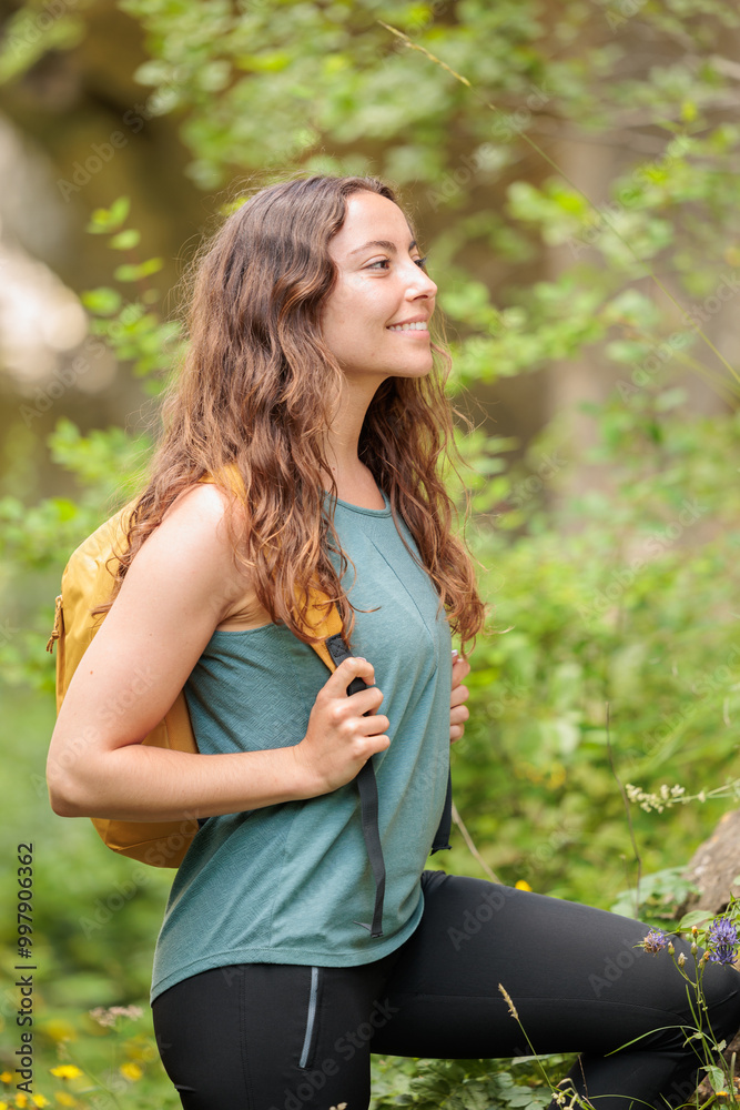 Fototapeta premium Young woman enjoying nature.Hiking in the mountains, observing the landscape.Doing sports and physical activity.Let's take care of our natural surroundings and our environment.Moments of disconnection