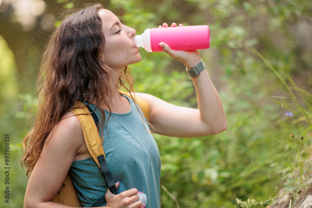 Young woman enjoying nature. Drinking water is very important and healthy. Always stay hydrated. Hiking in the mountains, observing the landscape. Practicing sports and physical activity. Moments Young woman enjoying nature. Drinking water is very important and healthy. Always stay hydrated. Hiking in the mountains, observing the landscape. Practicing sports and physical activity. Moments