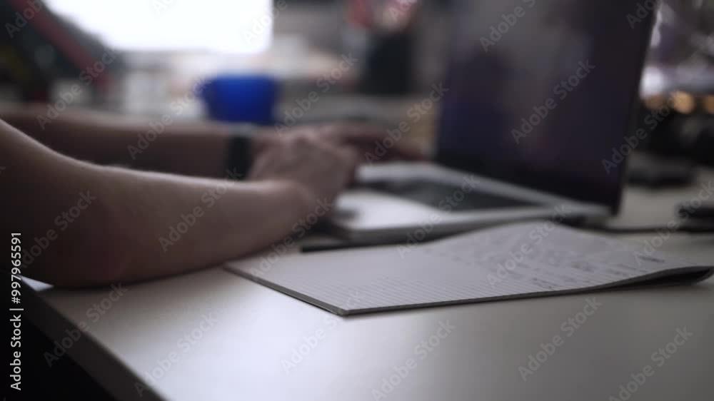 Man Working on Laptop and Taking Notes in Notebook Man Working on Laptop and Taking Notes in Notebook