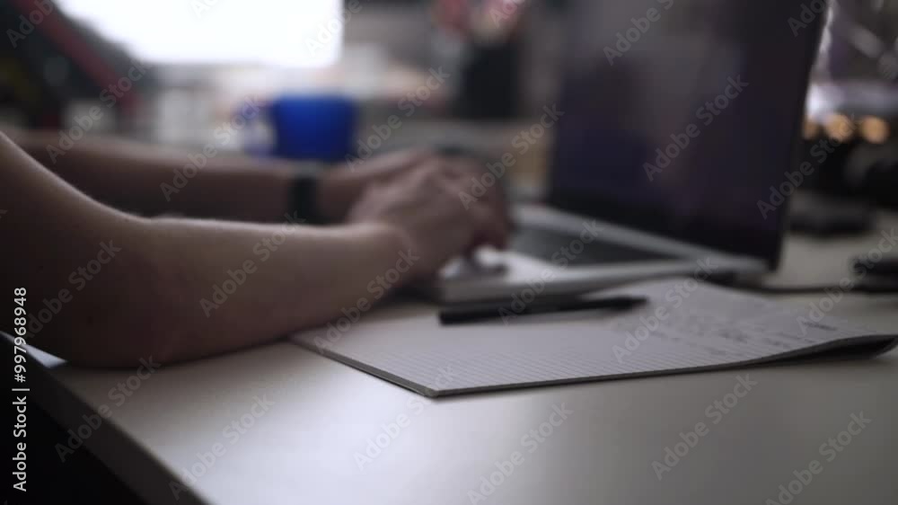 Man Working on Laptop and Taking Notes in Notebook