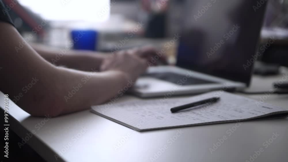 Man Working on Laptop and Taking Notes in Notebook Man Working on Laptop and Taking Notes in Notebook