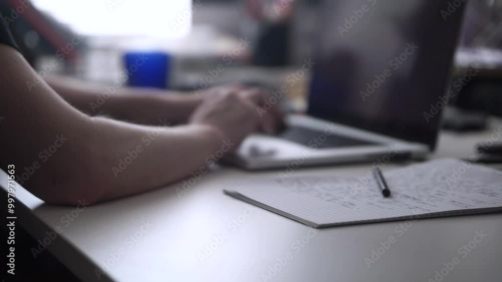 Man Working on Laptop and Taking Notes in Notebook Man Working on Laptop and Taking Notes in Notebook