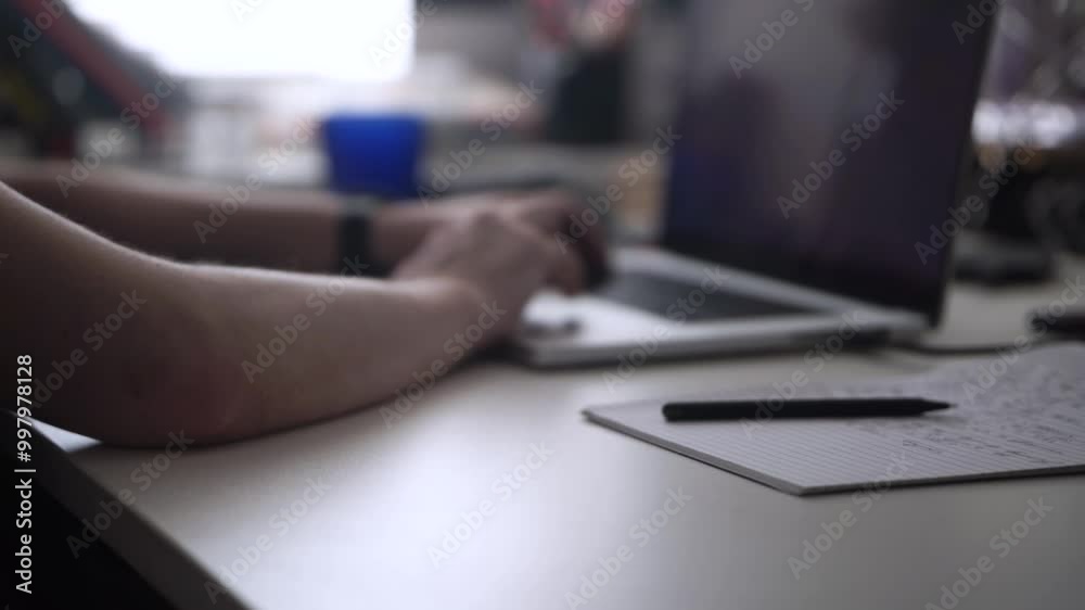Man Working on Laptop and Taking Notes in Notebook Man Working on Laptop and Taking Notes in Notebook