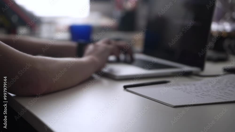 Man Working on Laptop and Taking Notes in Notebook Man Working on Laptop and Taking Notes in Notebook