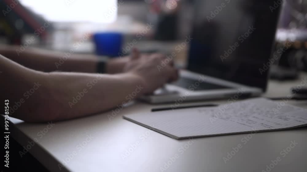 Man Working on Laptop and Taking Notes in Notebook Man Working on Laptop and Taking Notes in Notebook