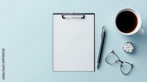 Organized workspace setup with clipboard, pen, coffee, glasses, and mints