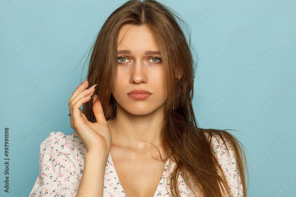 Fototapeta premium Woman in a summer dress on a blue background. Model, posing, emotions.