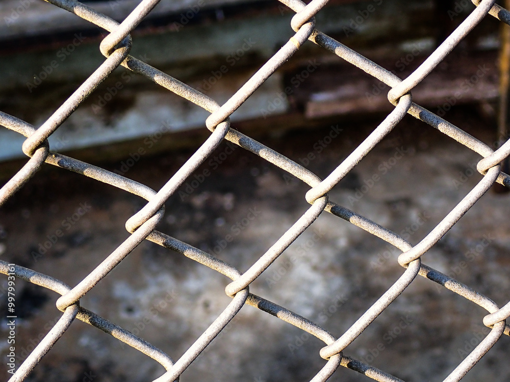 Chain link fence close up. Rusty steel mesh fence background. Texture of rusty metal wire. A perspective metal net wall with blur background. Chain link fence close up. Rusty steel mesh fence background. Texture of rusty metal wire. A perspective metal net wall with blur background.