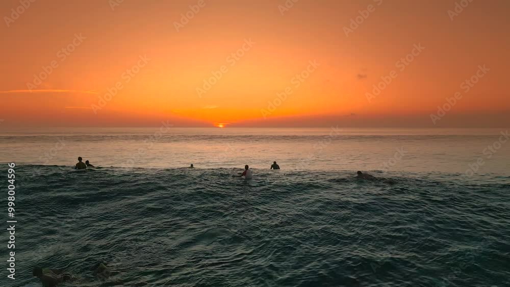 A beautiful aerial view of surfers enjoying the waves at sunset in Balangan Beach. A beautiful aerial view of surfers enjoying the waves at sunset in Balangan Beach.
