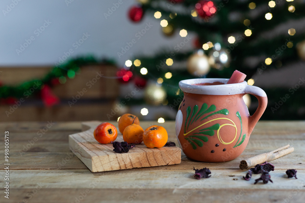 Fototapeta premium Typical Mexican Christmas punch on wooden table with Christmas tree in the background.