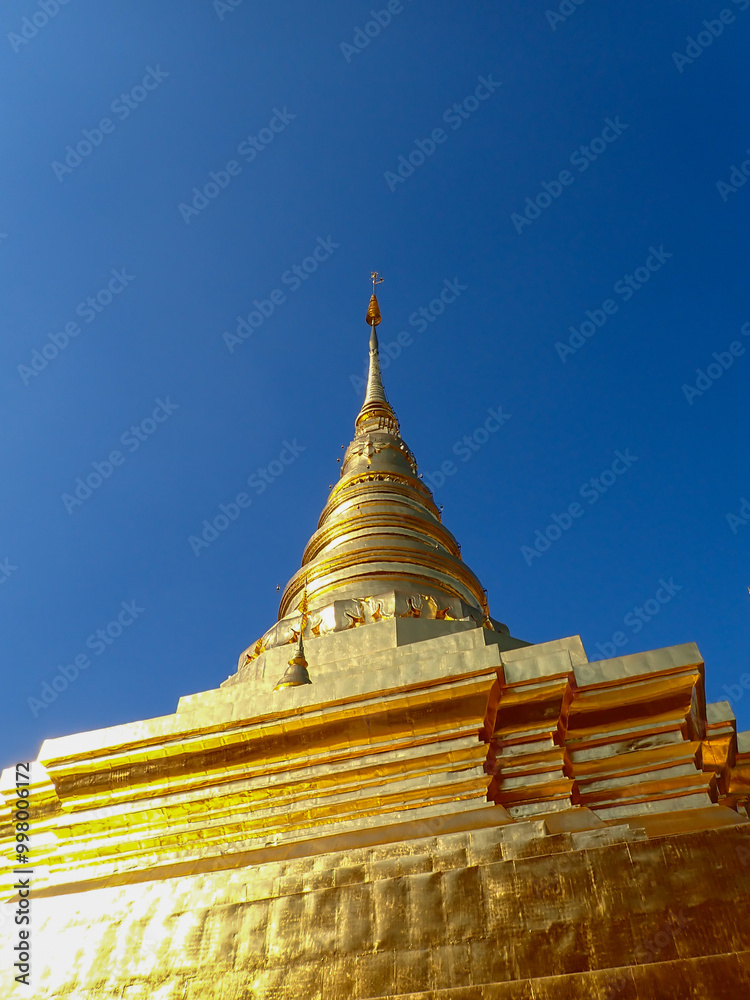 Fototapeta premium Beautiful temples in Thailand. Awesome view of the golden stupa at Wat Pavaranivesh Vihara Ratchawaraihan in Bangkok, Thailand. The amazing chedi of the Buddhist temple.