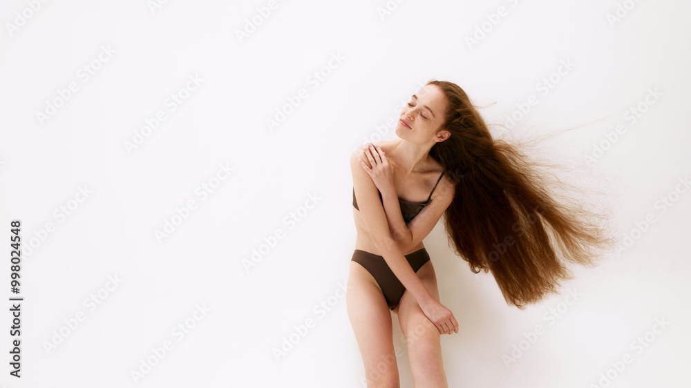 Obraz premium Self-care and wellness. Beautiful young red haired girl with slim body, posing in underwear isolated on white studio background. Concept of natural female beauty, body and skin care, health