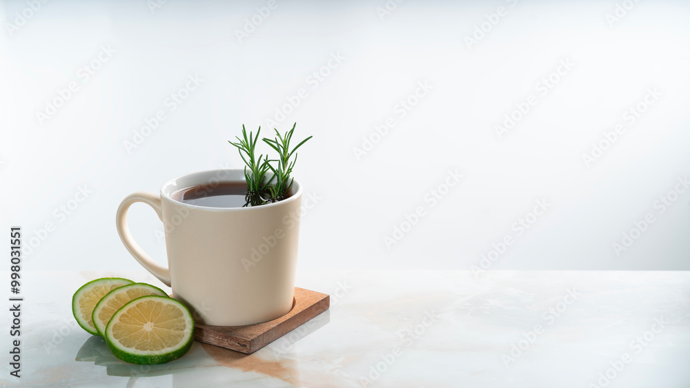 a mug of hot lemon tea with rosemary on granite table. a mug of hot lemon tea with rosemary on granite table.