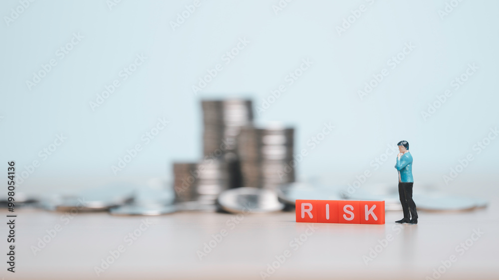 Stacking of coins and the emergence of the term RISK, which means a gradual reduction in financial risk or value. express concepts in finance, risk management financial strategy or investment planning