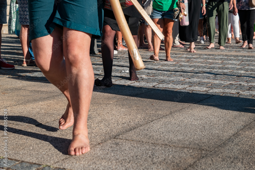 Pessoas a caminharem descalças em demonstrações de fé e em meio a promessas durante uma procissão religiosa ao ar livre Pessoas a caminharem descalças em demonstrações de fé e em meio a promessas durante uma procissão religiosa ao ar livre