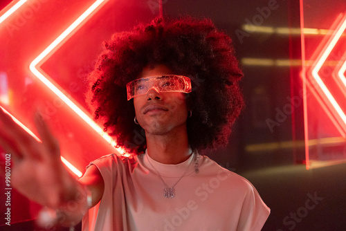 Young man with curly hair wearing red smart glasses photo