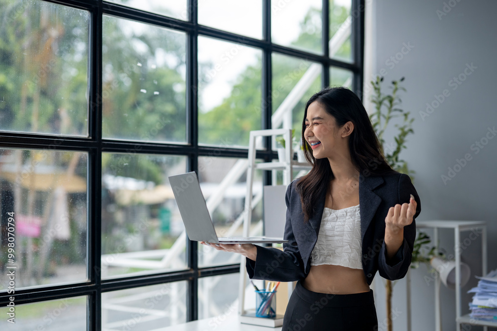 A woman is holding a laptop and smiling A woman is holding a laptop and smiling