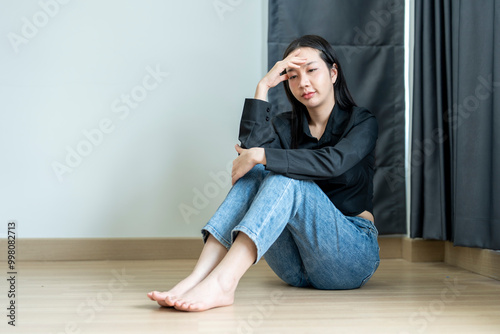 Young woman feeling sad and holding her head in her hands