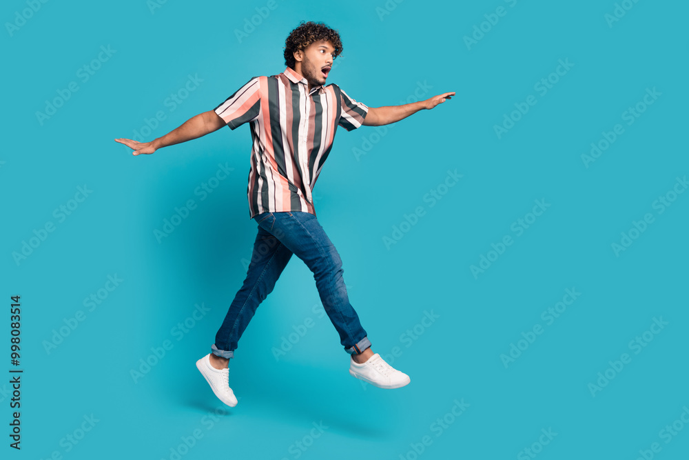 Full size photo of nice young man jump empty space wear shirt isolated on teal color background Full size photo of nice young man jump empty space wear shirt isolated on teal color background