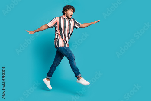 Full size photo of nice young man jump empty space wear shirt isolated on teal color background