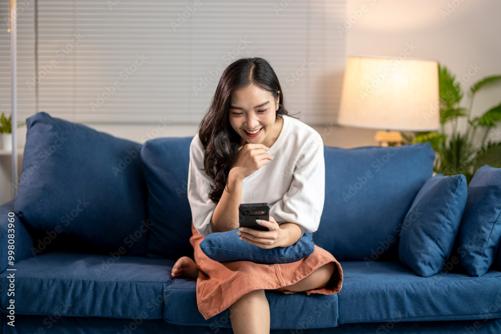 Young woman relaxing on sofa using smartphone at home Young woman relaxing on sofa using smartphone at home