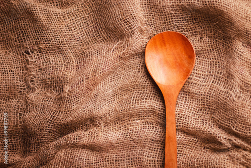 Top flat lay picture of a wooden spoon with space for text on the left side of the picture