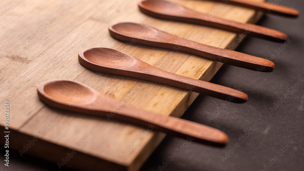 close up of 5 wooden spoons kept on a wooden table, empty spoons restaurant spoons