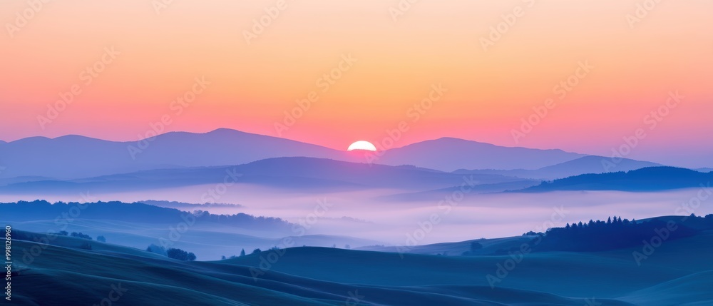 Fototapeta premium Breathtaking sunrise over rolling hills, enveloped in mist, showcasing vibrant colors and serene beauty.