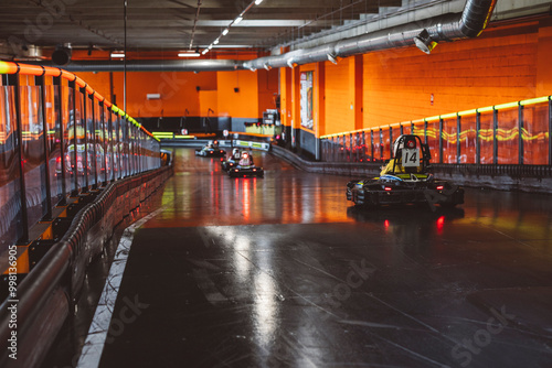 Go-Kart Racers Navigating a Turn on Indoor Track photo