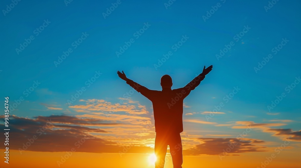 Silhouette of a person celebrating against a vibrant sunset sky over the horizon at dusk Silhouette of a person celebrating against a vibrant sunset sky over the horizon at dusk