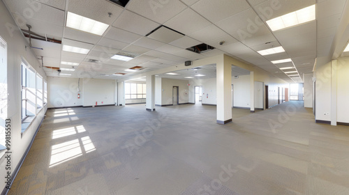 Spacious empty office interior with large windows, natural light, and neutral color palette. open layout offers flexibility for various configurations and designs