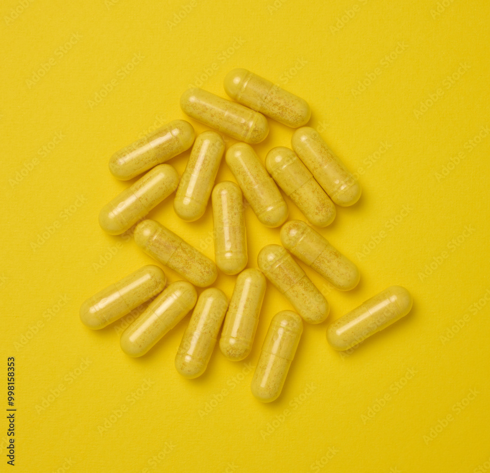 Yellow pills in a capsule on a yellow background, pain treatment Yellow pills in a capsule on a yellow background, pain treatment