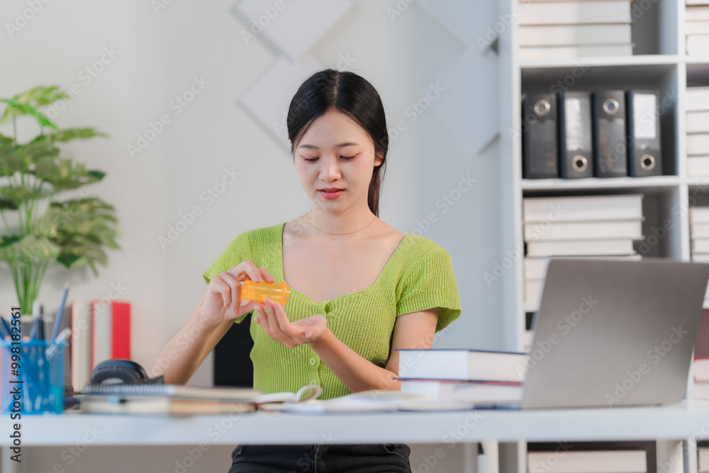 Focused on Finance: A young woman in a green top holds a credit card at her desk, her expression thoughtful as she considers her finances. Focused on Finance: A young woman in a green top holds a credit card at her desk, her expression thoughtful as she considers her finances.
