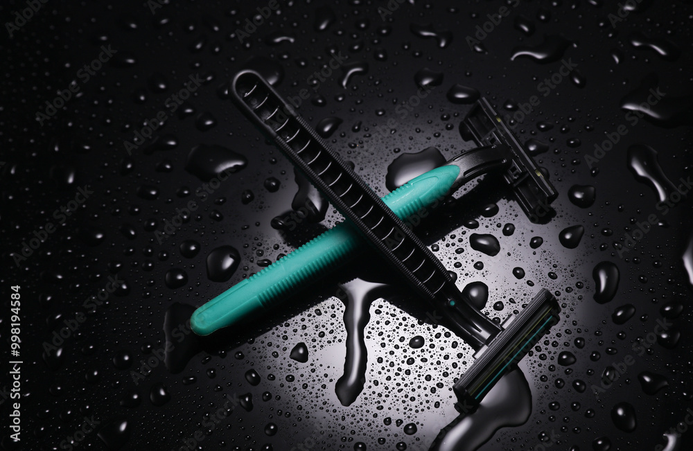 Disposable razors in water drops on a black background Disposable razors in water drops on a black background
