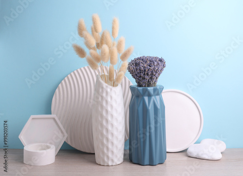 Vases with dry flowers and plaster shapers on a blue background. Minimalistic still life photo