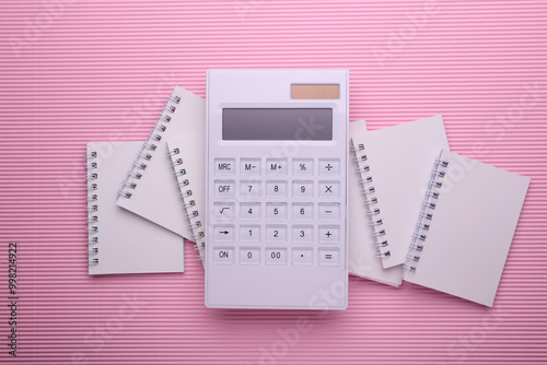 Group of Blank white spiral notebooks with calculator on pink background