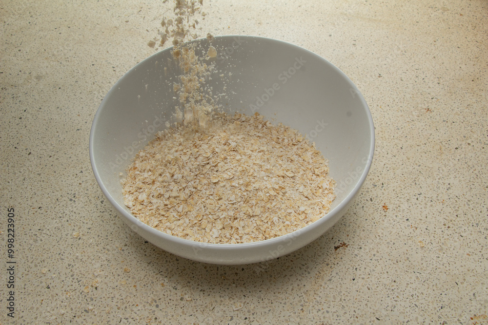 Pour dry wheat flour into a bowl white, oats, dry, breakfast, cereal,cereal Pour dry wheat flour into a bowl white, oats, dry, breakfast, cereal,cereal