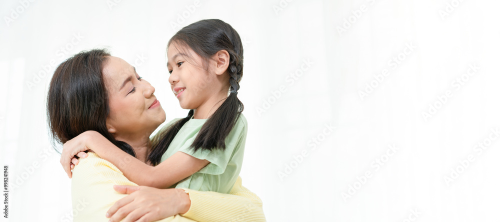 Woman embracing smiling child girl, Asian little girl hugging her mom at home, Mother's Day Concepts Woman embracing smiling child girl, Asian little girl hugging her mom at home, Mother's Day Concepts