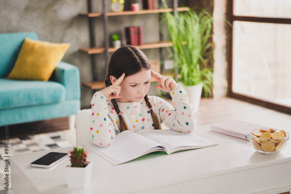 Portrait of cute little girl think focused read book study homework desktop apartment indoors Portrait of cute little girl think focused read book study homework desktop apartment indoors