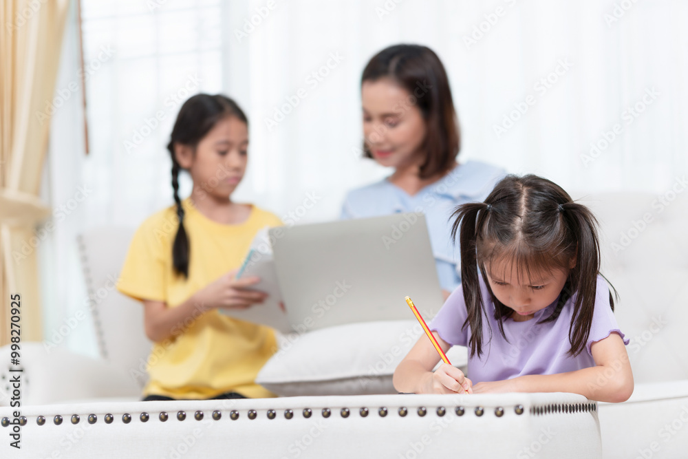 Child girl doing homework, Asian mother supervising daughters doing homework Child girl doing homework, Asian mother supervising daughters doing homework