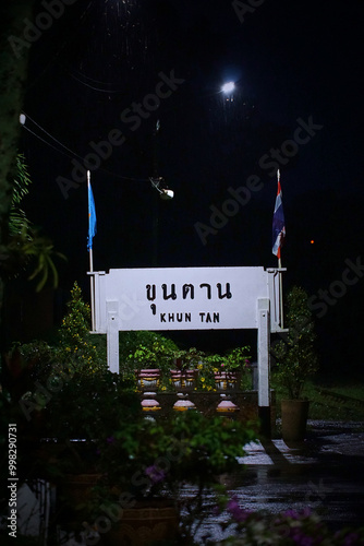 A sign with the word khun tan on it is lit up at night photo