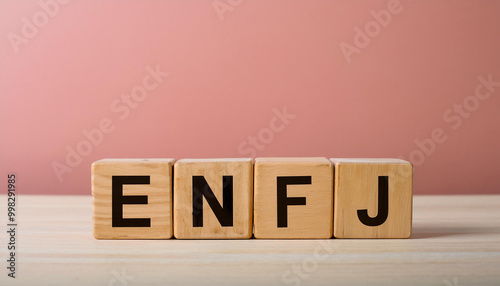 Wooden cubes with abbreviation ENFJ, pink wall. Extraverted, Intuitive, Feeling, Judging. MBTI photo