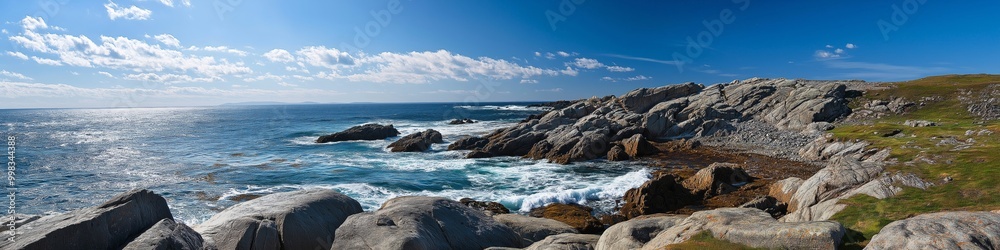 A beautiful ocean view with a rocky shoreline. The sky is clear and blue, and the water is calm. The rocks are scattered along the shoreline, and the grass is growing on the hillside A beautiful ocean view with a rocky shoreline. The sky is clear and blue, and the water is calm. The rocks are scattered along the shoreline, and the grass is growing on the hillside