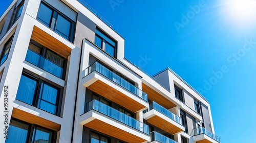 Contemporary luxury residential apartment. Modern building bathed in sunlight. Apartment complex against a clear blue sky. Facade of a state-of-the-art apartment building. 