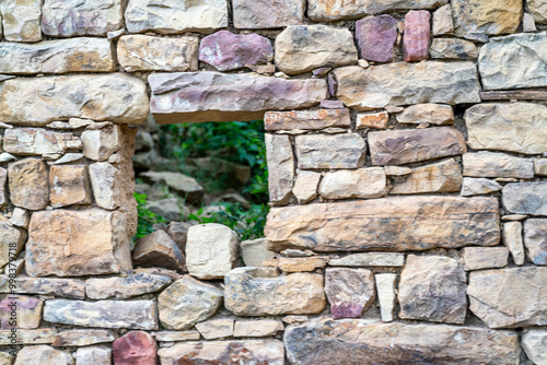 A stone wall with a small window in it