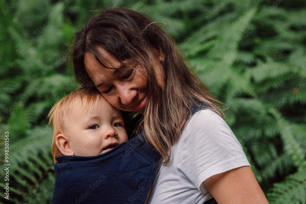 Mother with her cute baby daughter in park between fern leaves Mother with her cute baby daughter in park between fern leaves