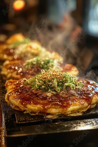 Okonomiyaki - A savory Japanese pancake made with batter, cabbage, and toppings like meat or seafood, often drizzled with sauce.