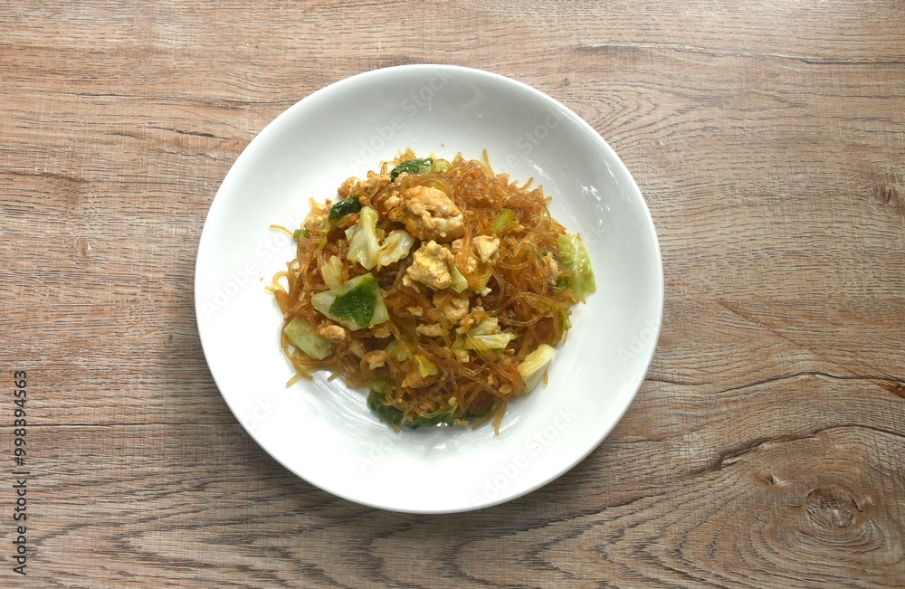 fried glass noodles with egg and cabbage in black sweet soy sauce on plate fried glass noodles with egg and cabbage in black sweet soy sauce on plate