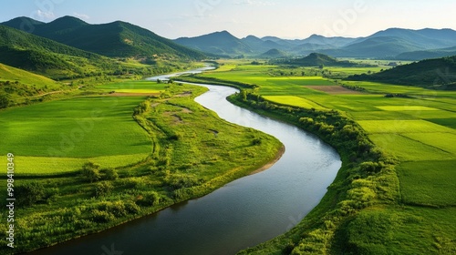 A peaceful river meandering through a lush valley with vibrant green fields and distant hills.