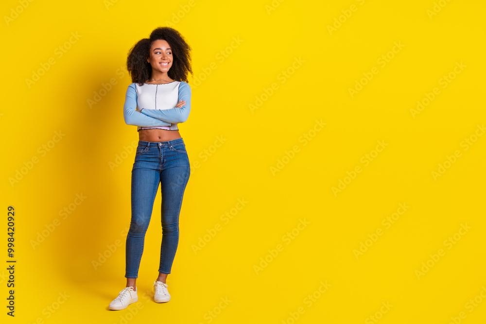 Full size photo of lovely girl dressed stylish shirt holding arms folded look empty space isolated on vibrant yellow color background Full size photo of lovely girl dressed stylish shirt holding arms folded look empty space isolated on vibrant yellow color background